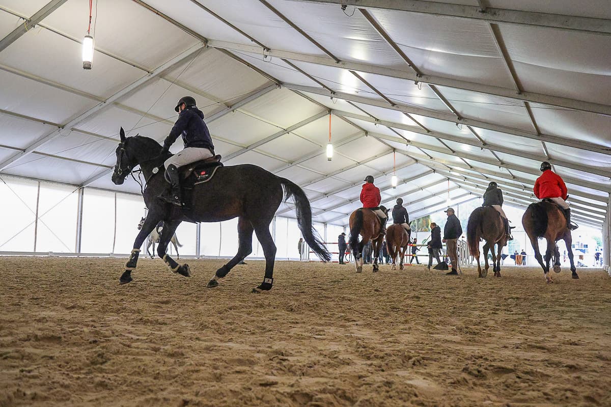 Riders warming up in the tent arena at CSI Chevenez