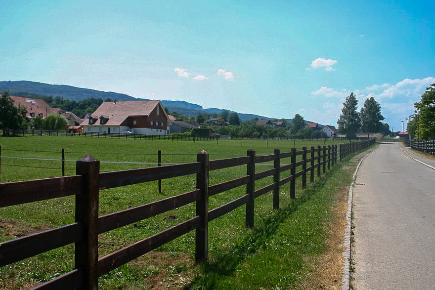 Open fenced meadows at Ecurie Chevenez in summer